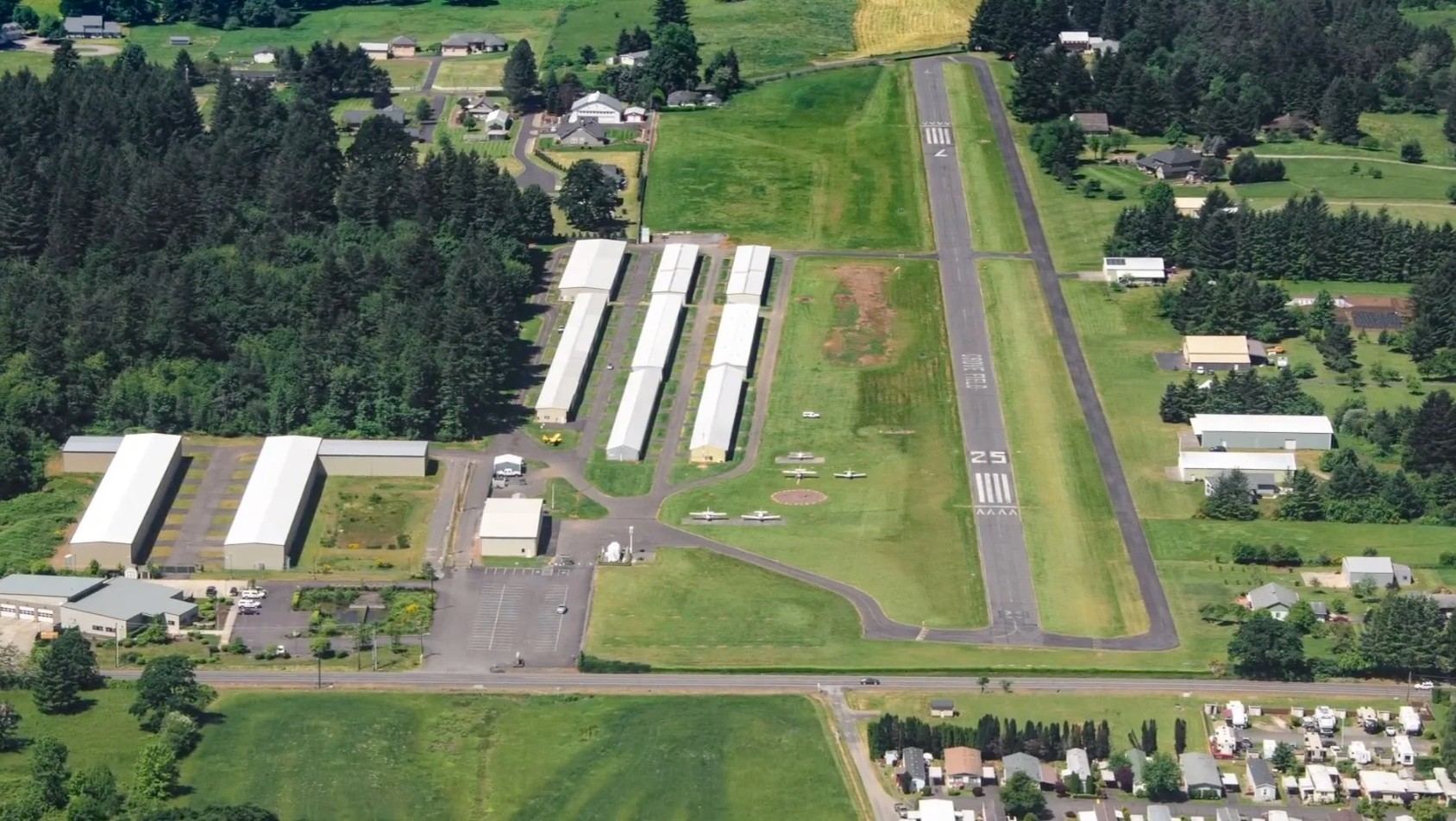 Aerial view of Grove Field's runway, taxiways and hangars, surrounded by trees and the Camas–Washougal neighborhood